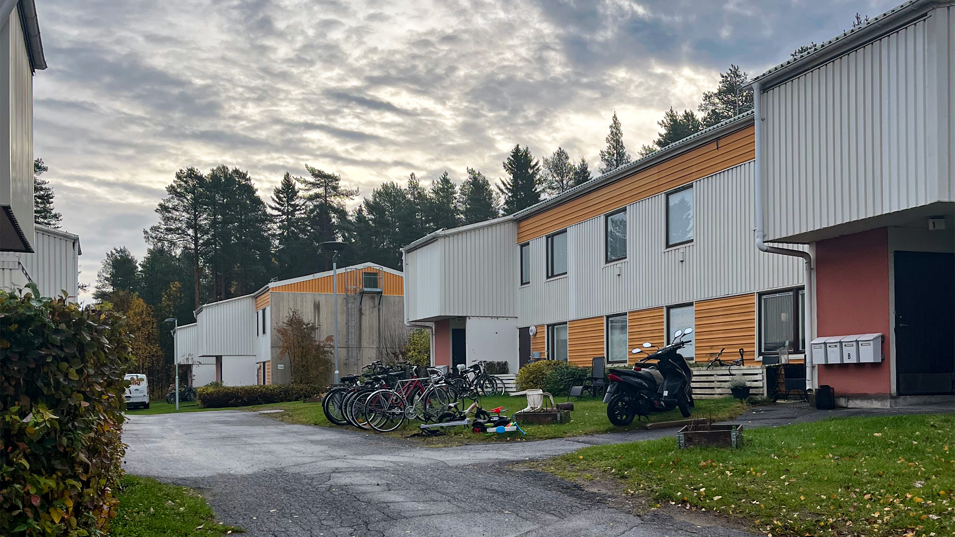 Gula och vita lamellhus på Lävägen på Björkskatan, sommartid, cyklar och mopeder står parkerade uta